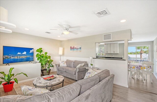 living room with light wood-type flooring and ceiling fan