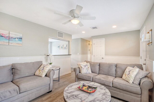 living room with ceiling fan and light hardwood / wood-style flooring