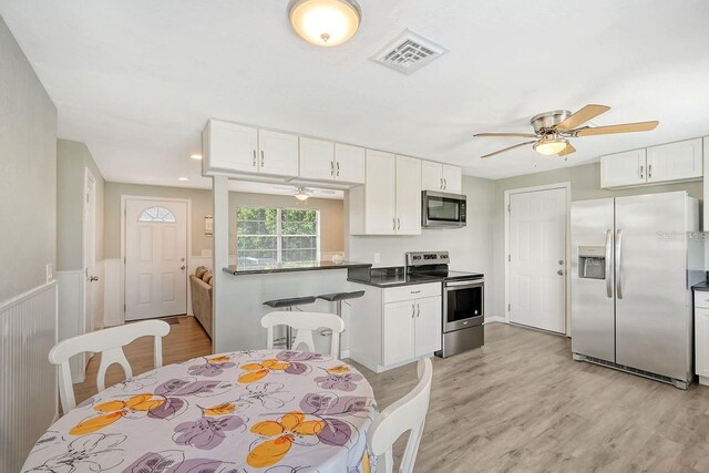 kitchen featuring light hardwood / wood-style flooring, stainless steel appliances, ceiling fan, and white cabinets