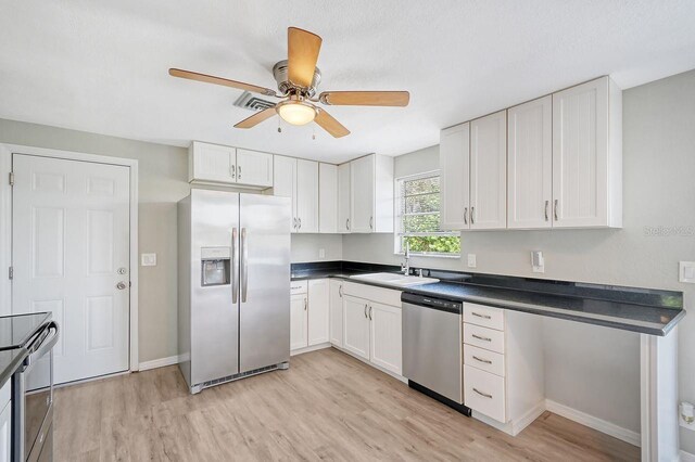 kitchen with white cabinetry, light hardwood / wood-style flooring, stainless steel appliances, sink, and ceiling fan