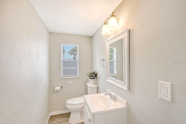 bathroom with hardwood / wood-style floors, toilet, and vanity