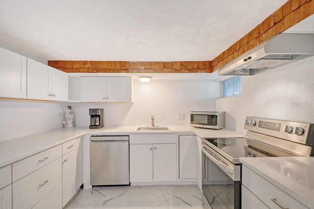 kitchen with sink, appliances with stainless steel finishes, and white cabinetry