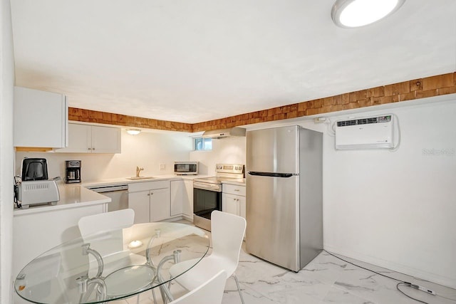 kitchen with white cabinets, appliances with stainless steel finishes, sink, and a wall mounted air conditioner