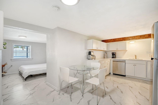 kitchen with appliances with stainless steel finishes, white cabinetry, and sink