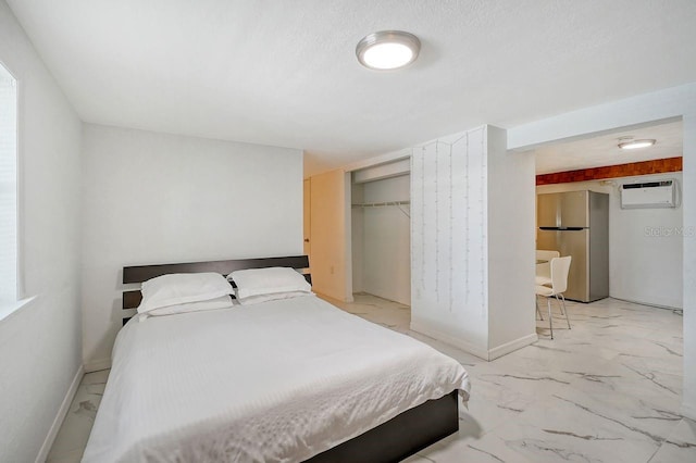 bedroom featuring a textured ceiling, a wall unit AC, stainless steel refrigerator, and a closet