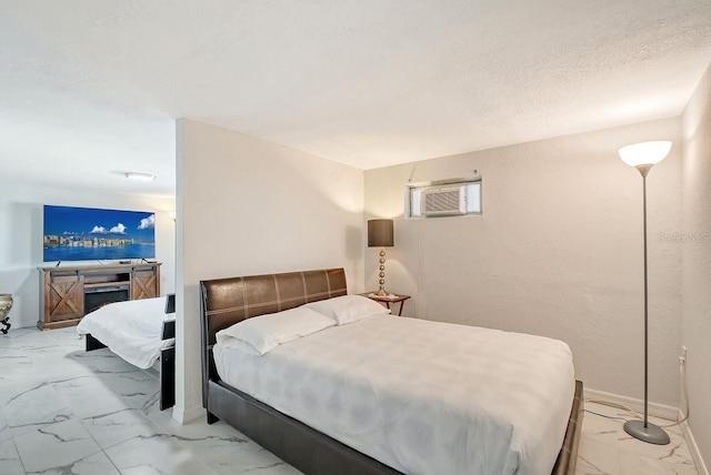 bedroom featuring a wall mounted AC and a textured ceiling