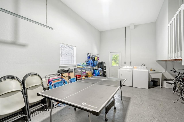 playroom with a towering ceiling and separate washer and dryer