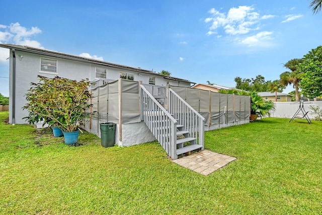 back of property with a yard and a pool