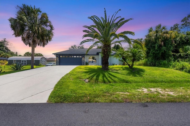 view of front facade with a garage and a lawn