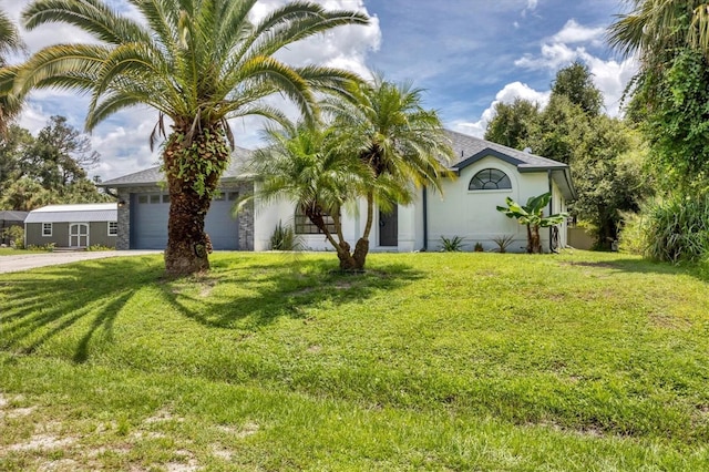 view of front of property featuring a front yard and a garage