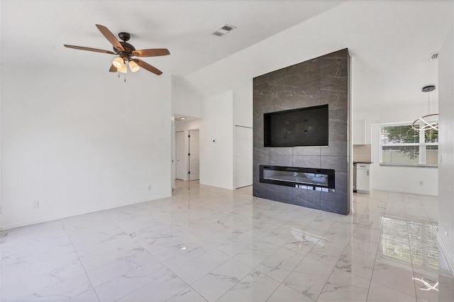 unfurnished living room with tile walls, ceiling fan, a large fireplace, and light tile patterned floors