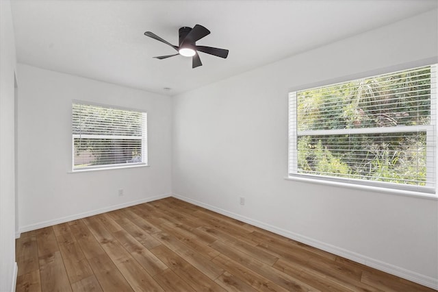 empty room featuring hardwood / wood-style flooring, plenty of natural light, and ceiling fan