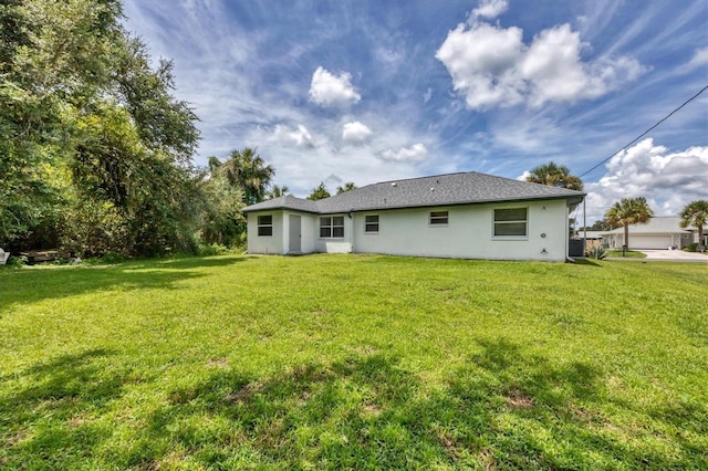 back of house featuring a lawn and a garage