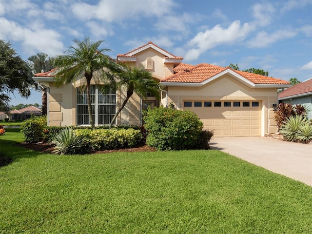 mediterranean / spanish house featuring stucco siding, concrete driveway, a front yard, a garage, and a tiled roof