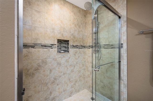 full bath with a shower stall and a textured wall