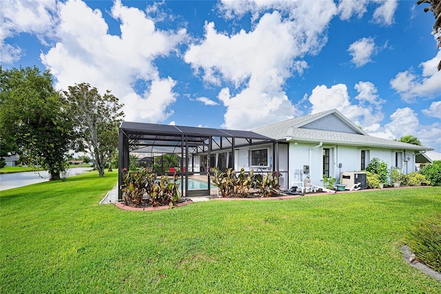 back of property featuring glass enclosure, an outdoor pool, a lawn, and stucco siding