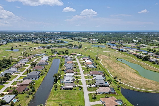 drone / aerial view with view of golf course, a water view, and a residential view