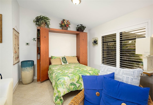 bedroom with light tile patterned floors and baseboards