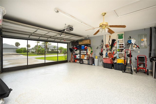 garage featuring electric panel, ceiling fan, and a garage door opener