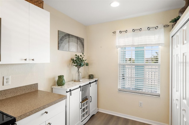 kitchen with hardwood / wood-style flooring and white cabinets