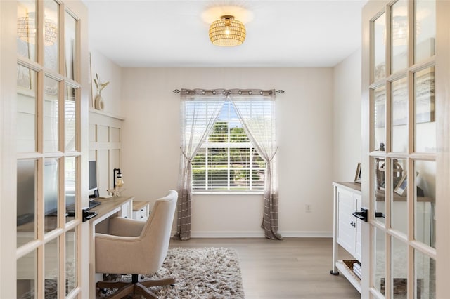 home office featuring light hardwood / wood-style floors and french doors