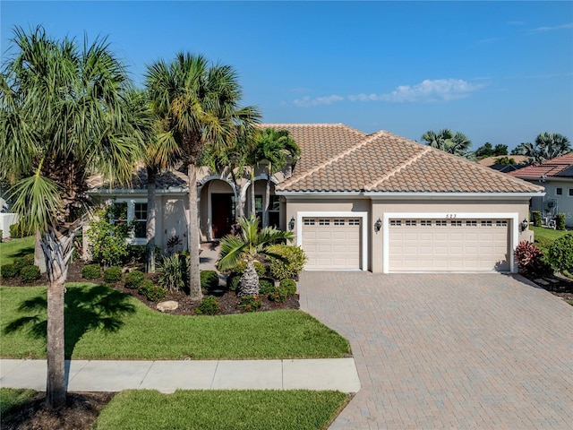 mediterranean / spanish-style home featuring a garage and a front yard