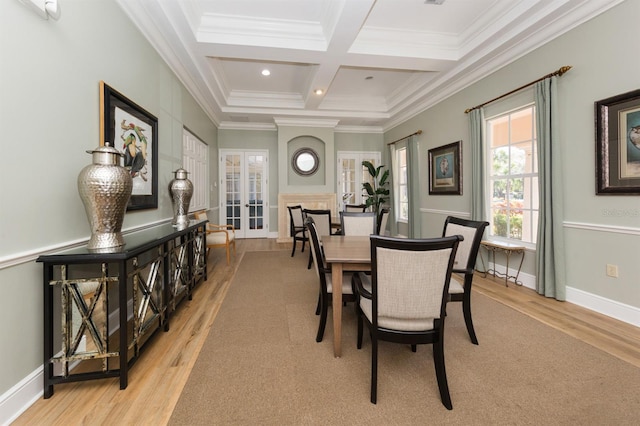 dining room with light wood-type flooring, crown molding, beamed ceiling, and coffered ceiling