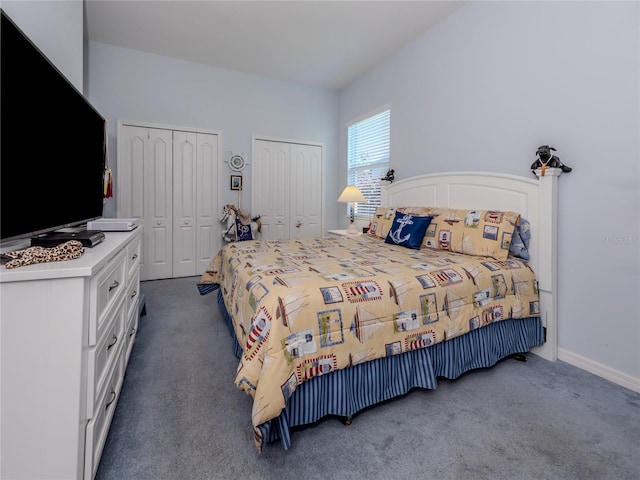 bedroom featuring dark carpet and multiple closets