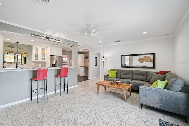 living room with ceiling fan, sink, and crown molding