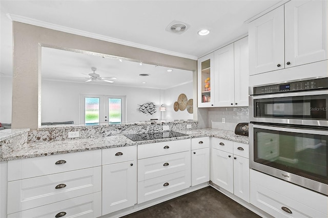 kitchen with ceiling fan, tasteful backsplash, white cabinets, light stone counters, and double oven