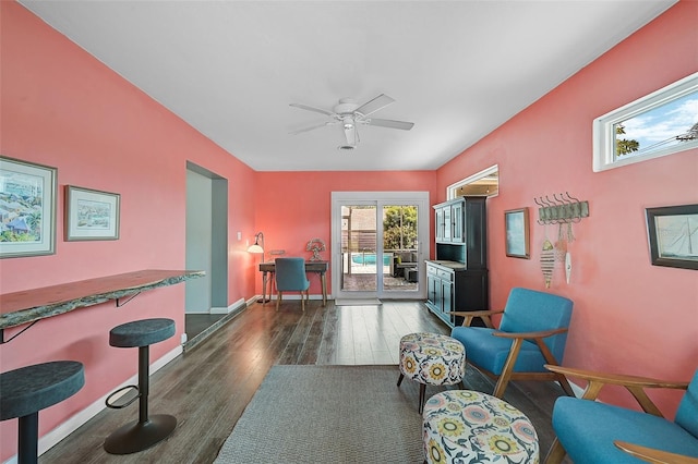 living room with ceiling fan and dark wood-type flooring