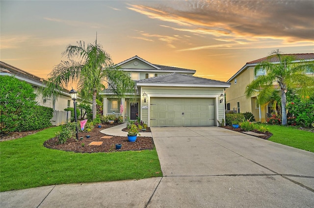 view of front of house featuring a garage and a lawn