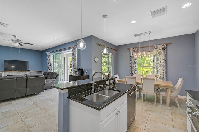 kitchen with dark stone counters, sink, white cabinetry, ceiling fan, and hanging light fixtures