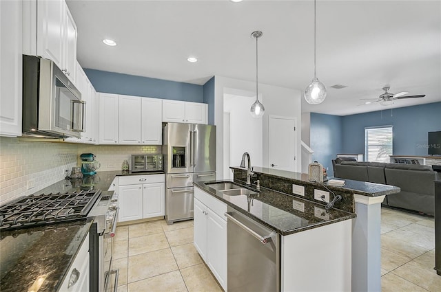 kitchen featuring stainless steel appliances, decorative backsplash, sink, a kitchen island with sink, and light tile patterned flooring