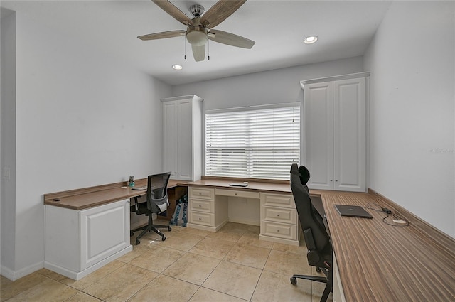 tiled office space featuring ceiling fan and built in desk