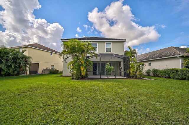 rear view of property featuring a lawn, a patio area, and a lanai