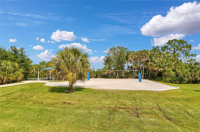 view of home's community with volleyball court and a yard