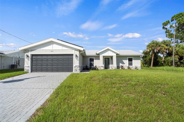 view of front of house featuring a garage, central AC unit, and a front lawn