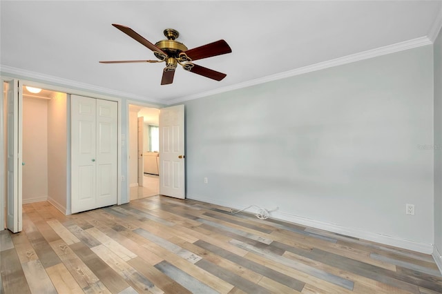 unfurnished bedroom with ornamental molding, light hardwood / wood-style flooring, ceiling fan, and a closet