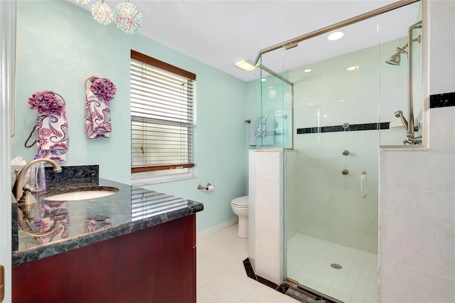 bathroom featuring vanity, toilet, tile patterned floors, and a shower with shower door