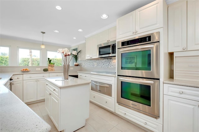 kitchen with hanging light fixtures, light tile patterned floors, stainless steel appliances, a kitchen island, and decorative backsplash