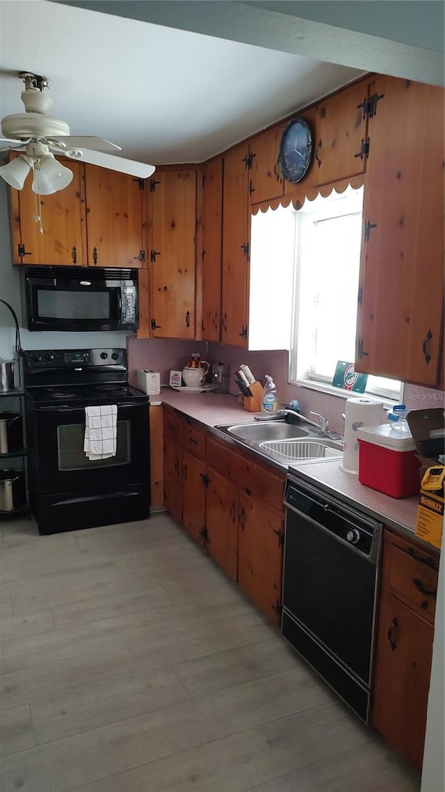 kitchen with ceiling fan, sink, light hardwood / wood-style flooring, and black appliances