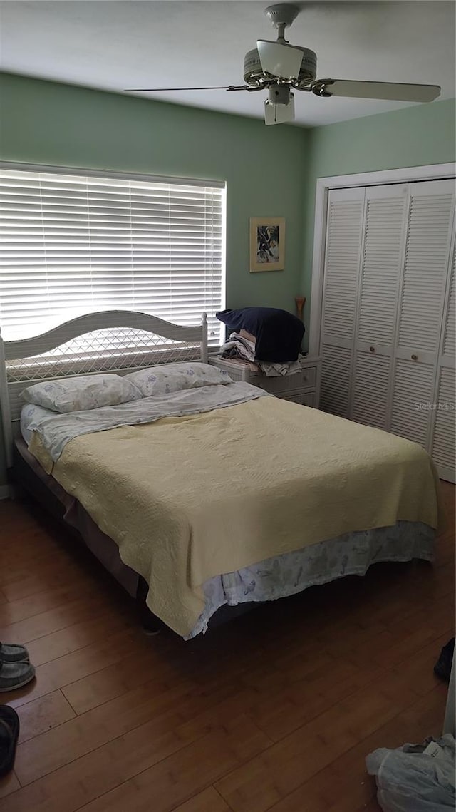 bedroom featuring hardwood / wood-style floors, ceiling fan, and a closet