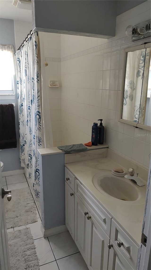 bathroom with tile patterned flooring, tile walls, and vanity