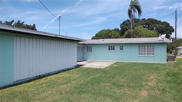 rear view of property with a patio and a lawn