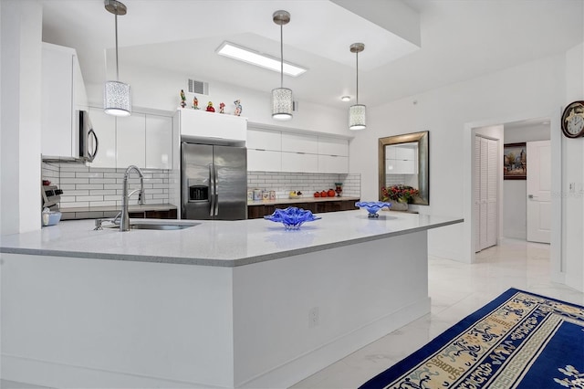 kitchen with stainless steel appliances, white cabinets, light stone counters, and tasteful backsplash