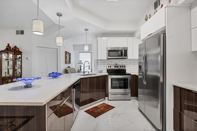 kitchen with appliances with stainless steel finishes, backsplash, sink, white cabinets, and light tile patterned flooring