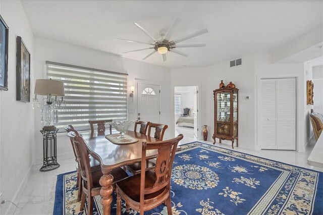 dining area with ceiling fan and tile patterned floors