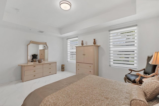 bedroom with marble finish floor, visible vents, and a raised ceiling