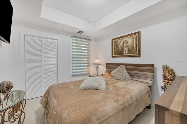 bedroom featuring a closet and a tray ceiling